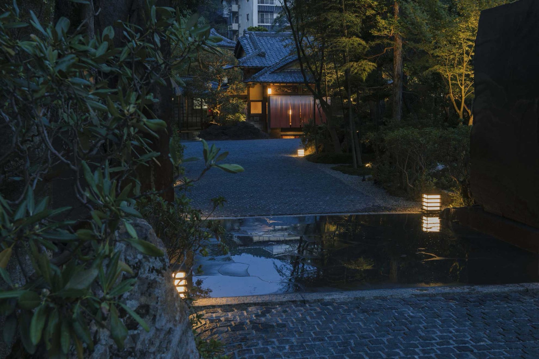 Lantern-lit stone approach to the ryokan at dusk